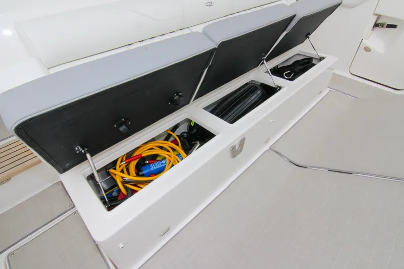 Slide: The Image of 2023 Regal 38 SAV boat storage compartment with open lids, revealing organized equipment. - 18
