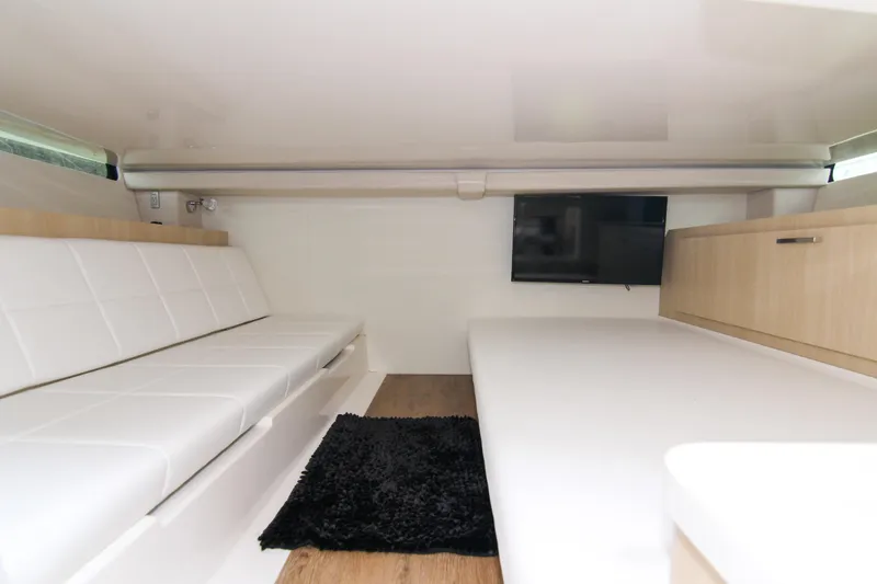 Slide: The Image of 2023 Regal 38 SAV interior with white seating, TV, and black rug. - 25