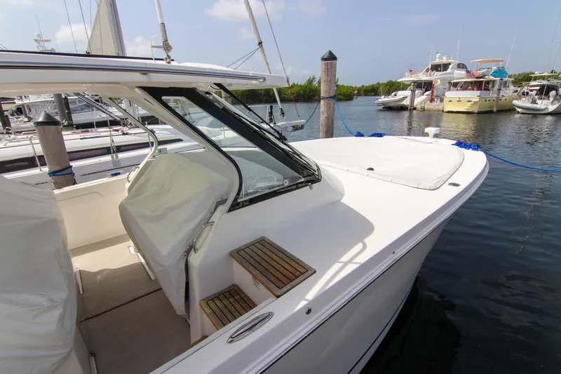 Slide: The Image of 2023 Regal 38 SAV boat docked in a marina, showcasing sleek design and spacious deck. - 29