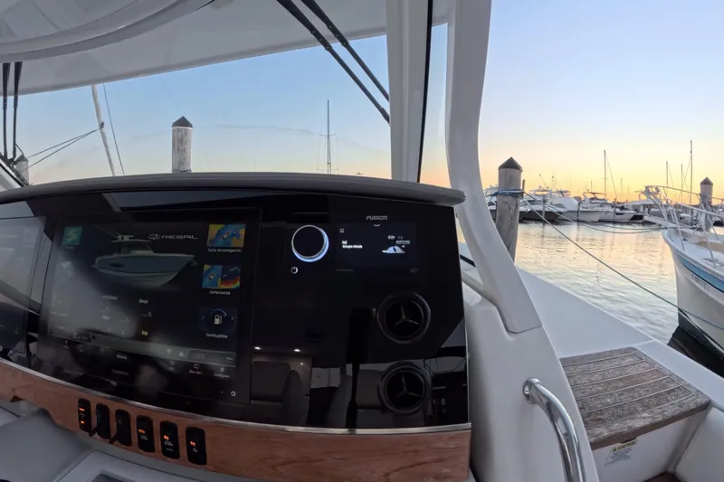 Slide: The Image of Helm of 2023 Regal 38 SAV boat with advanced navigation system at sunset marina. - 35