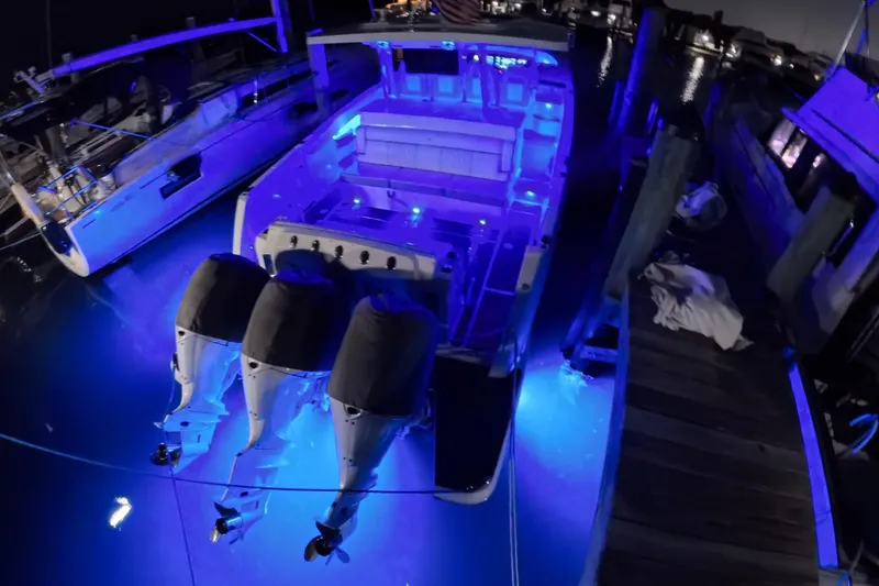 Slide: The Image of 2023 Regal 38 SAV boat illuminated with blue lights at night dock. - 41