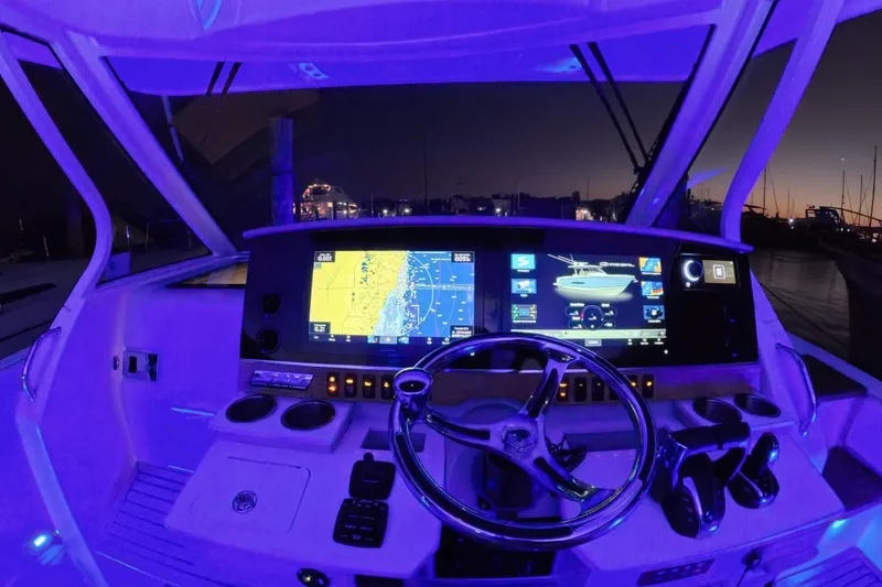 Slide: The Image of Cockpit of 2023 Regal 38 SAV boat with illuminated dashboard and navigation screens at dusk. - 42