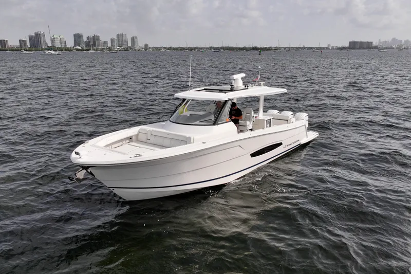 Slide: The Image of 2023 Regal 38 SAV boat cruising on open water near city skyline. - 5