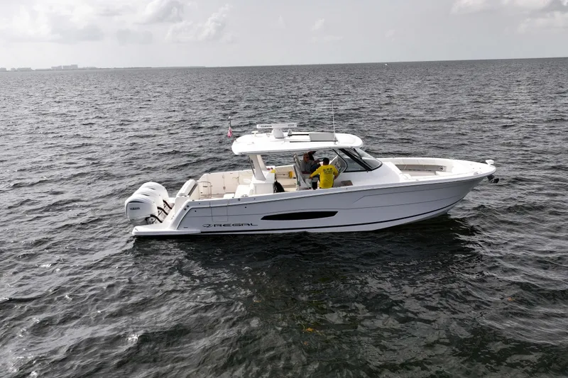 Slide: The Image of 2023 Regal 38 SAV boat cruising on open water under cloudy skies. - 7