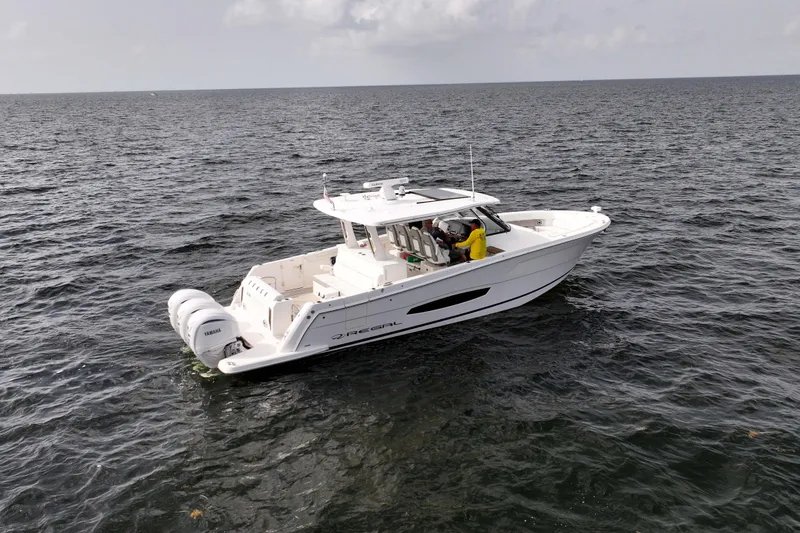 Slide: The Image of 2023 Regal 38 SAV boat on open water, featuring triple Yamaha engines. - 8