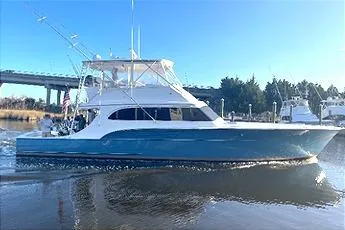 The Image of 1989 Buddy Davis 61 Sportfish yacht cruising on a sunny day near a bridge. - 0