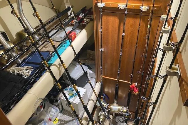 Slide: The Image of Fishing rods and gear inside a 1989 Buddy Davis 61 Sportfish boat cabin. - 21