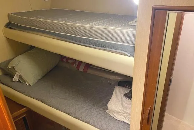 Slide: The Image of Bunk beds in 1989 Buddy Davis 61 Sportfish cabin, featuring cozy bedding and compact design. - 25