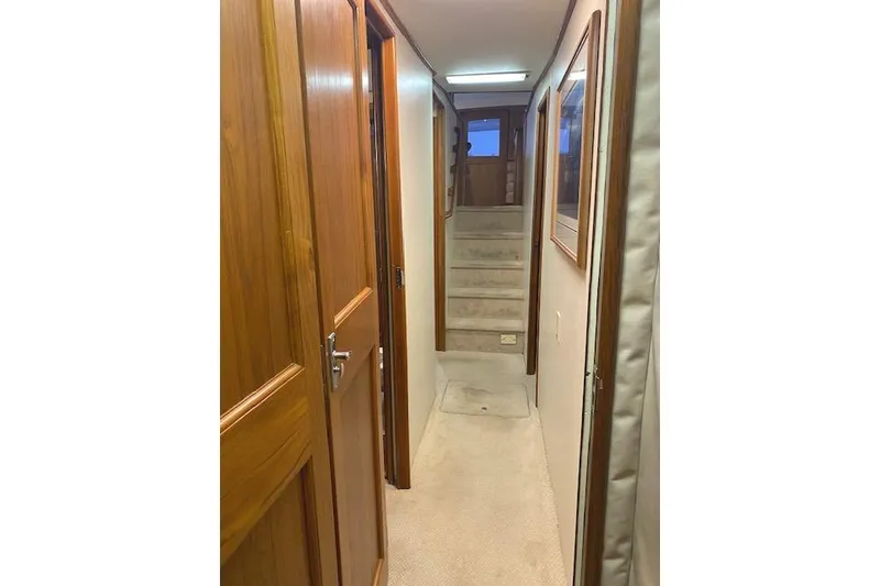 Slide: The Image of Interior hallway of 1989 Buddy Davis 61 Sportfish yacht with wooden doors and carpeted floor. - 29