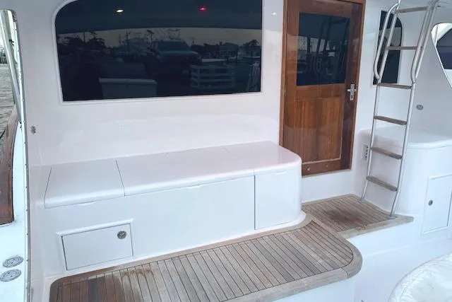 Slide: The Image of 1989 Buddy Davis 61 Sportfish boat deck with seating and wooden door. - 3