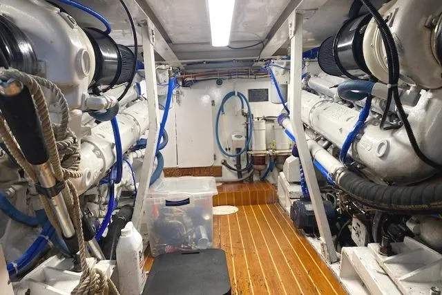 Slide: The Image of Engine room of 1989 Buddy Davis 61 Sportfish with dual engines and wooden flooring. - 30