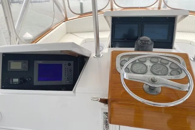 Slide: The Image of Helm of 1989 Buddy Davis 61 Sportfish with navigation instruments and steering wheel. - 37