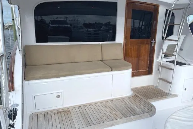 Slide: The Image of 1989 Buddy Davis 61 Sportfish yacht deck with seating, wooden door, and ladder. - 4