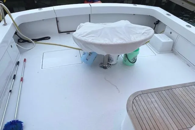 Slide: The Image of 1989 Buddy Davis 61 Sportfish boat deck with fishing chair and cleaning supplies. - 5