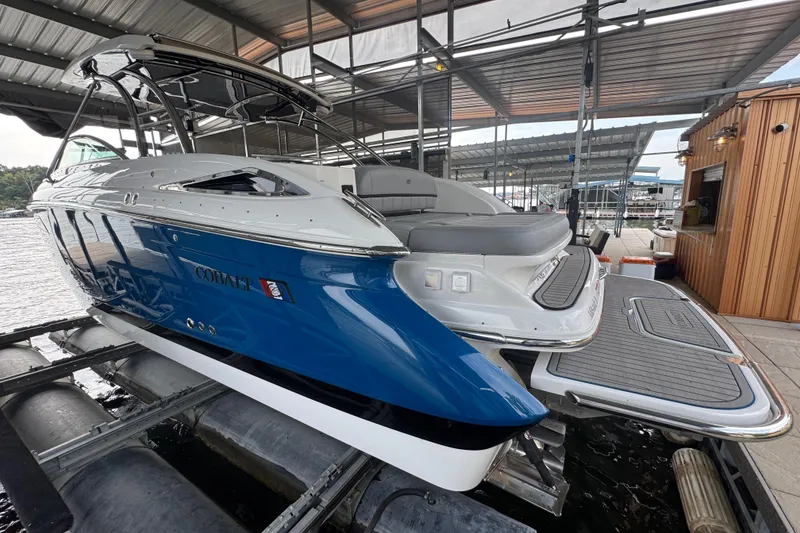 Slide: The Image of 2022 Cobalt R35 boat in dock, featuring sleek blue and white design. - 2