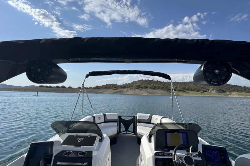 Slide: The Image of 2026 Paradigm Boats 27SST on serene lake, featuring modern dashboard and spacious seating. - 11