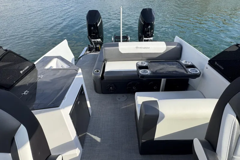 Slide: The Image of 2026 Paradigm Boats 27SST interior with seating, table, and dual outboard motors. - 12