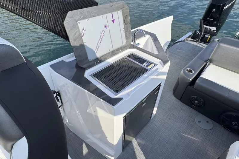 Slide: The Image of 2026 Paradigm Boats 27SST interior with grill and seating area on water. - 13