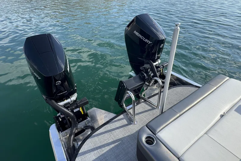 Slide: The Image of Twin Mercury outboard engines on a 2026 Paradigm Boats 27SST, docked on calm water. - 14