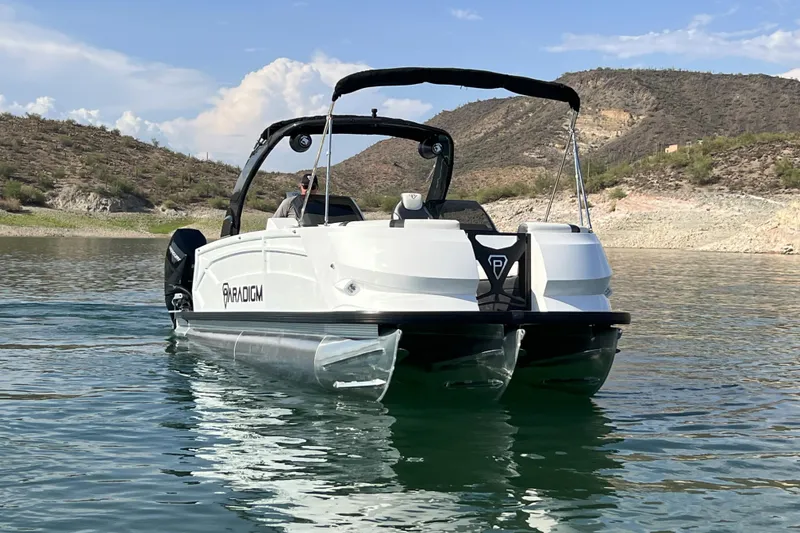 Slide: The Image of 2026 Paradigm Boats 27SST on a serene lake with scenic hills in the background. - 16