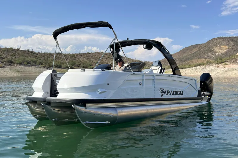 Slide: The Image of 2026 Paradigm Boats 27SST on a serene lake with scenic background. - 2