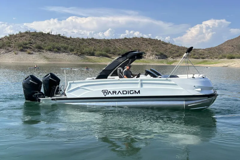 Slide: The Image of 2026 Paradigm Boats 27SST on a serene lake with scenic hills in the background. - 5