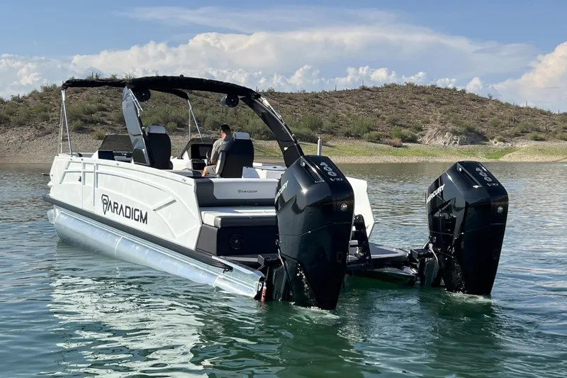 Slide: The Image of 2026 Paradigm Boats 27SST on a serene lake with dual Mercury engines. - 9