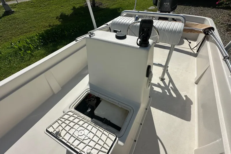 Slide: The Image of 2024 Carolina Skiff E24 DLX CC boat interior with open storage compartment and console. - 12