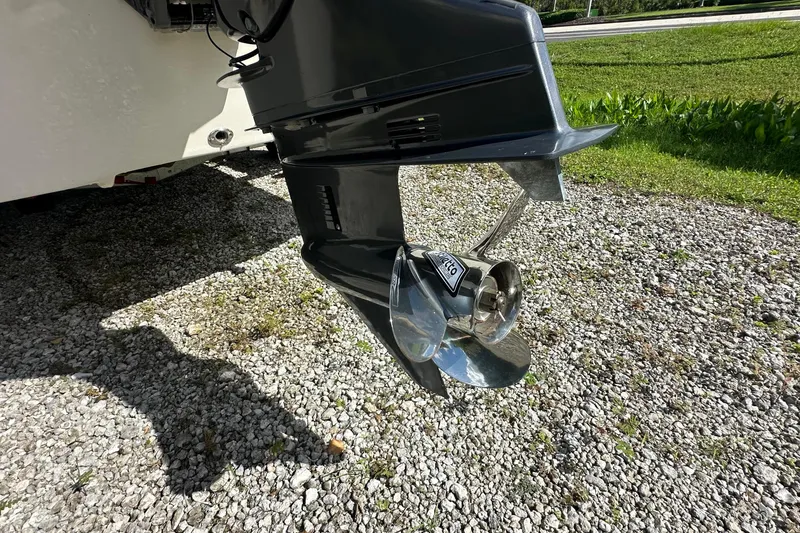 Slide: The Image of 2024 Carolina Skiff E24 DLX CC outboard motor on gravel surface. - 5