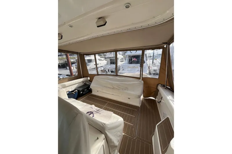 Slide: The Image of 1999 Tiara Yachts 4000 Express interior with covered seating and large windows. - 16