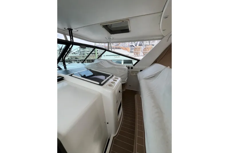 Slide: The Image of 1999 Tiara Yachts 4000 Express interior with covered seating and helm station. - 18