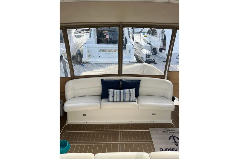 Slide: The Image of 1999 Tiara Yachts 4000 Express interior with white seating and nautical decor. - 26