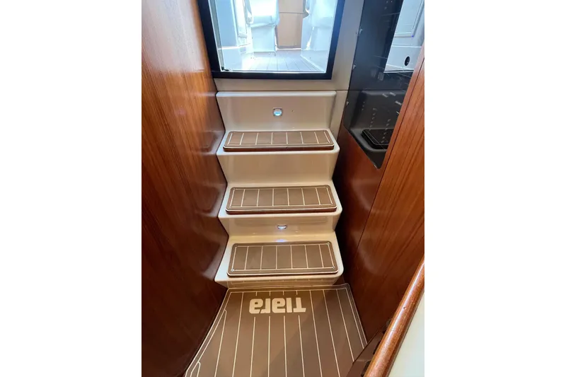 Slide: The Image of Staircase inside 1999 Tiara Yachts 4000 Express with wooden accents and branded mat. - 30
