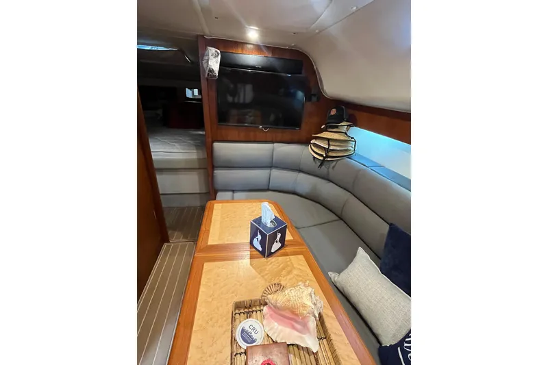 Slide: The Image of Interior of 1999 Tiara Yachts 4000 Express with cozy seating and elegant wood finishes. - 32