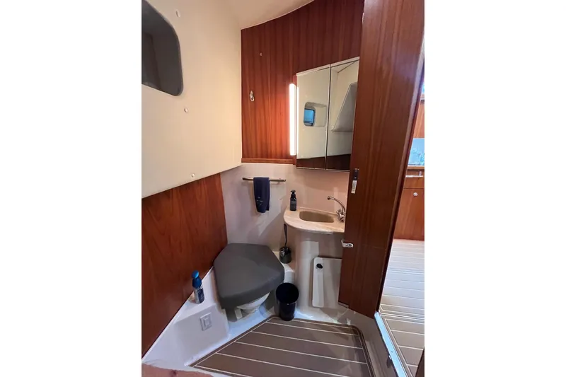 Slide: The Image of Bathroom interior of 1999 Tiara Yachts 4000 Express with wood paneling and compact fixtures. - 34