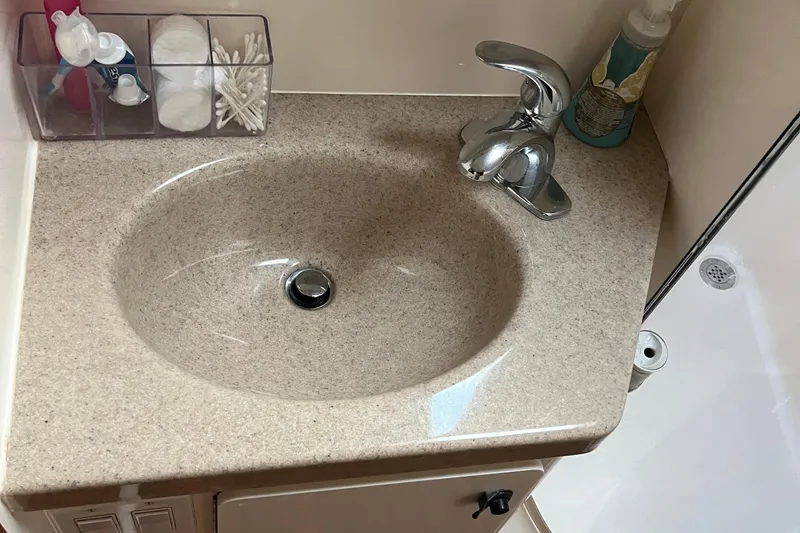 Slide: The Image of Bathroom sink area in a 1999 Tiara Yachts 4000 Express, featuring toiletries and a modern faucet. - 41