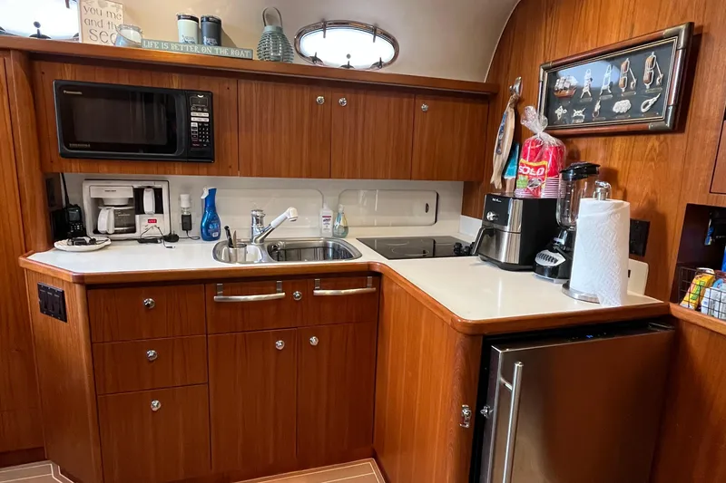 Slide: The Image of 1999 Tiara Yachts 4000 Express kitchen with wood cabinetry, microwave, and sink. - 44