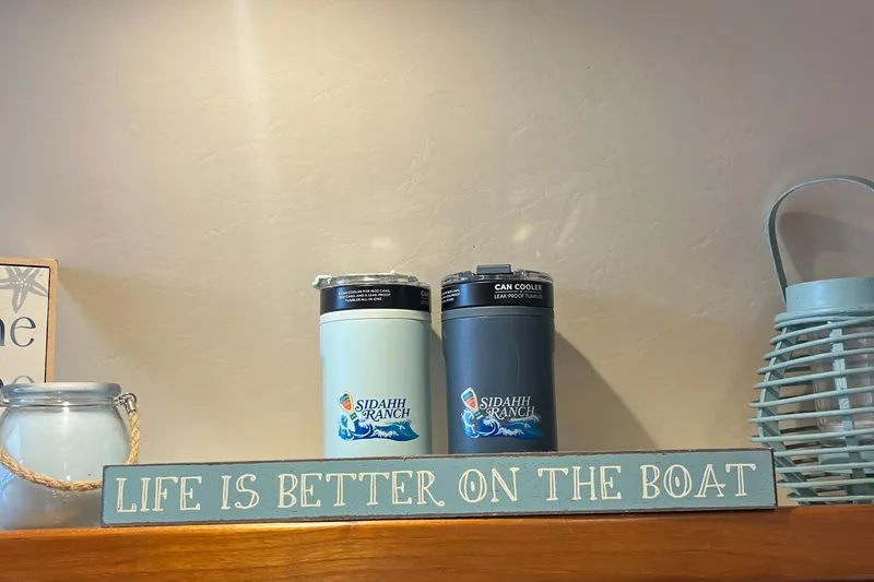 Slide: The Image of "Life is better on the boat" sign with can coolers and lantern. - 45