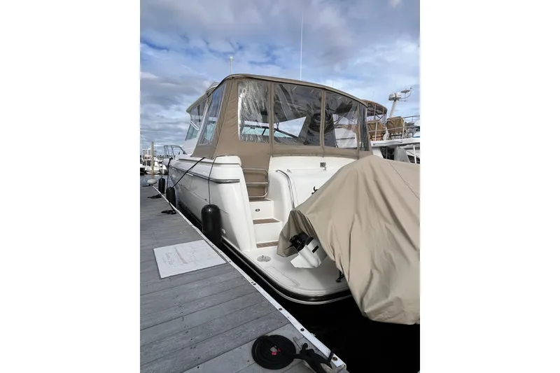 Slide: The Image of 1999 Tiara Yachts 4000 Express docked, featuring beige canopy and covered equipment. - 8