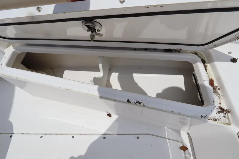 Slide: The Image of Open storage compartment on 2020 Everglades 243 Center Console boat, showing interior and debris. - 14