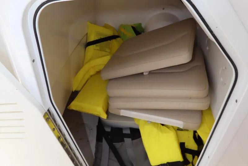 Slide: The Image of Storage compartment of 2020 Everglades 243 Center Console with life jackets and cushions. - 15