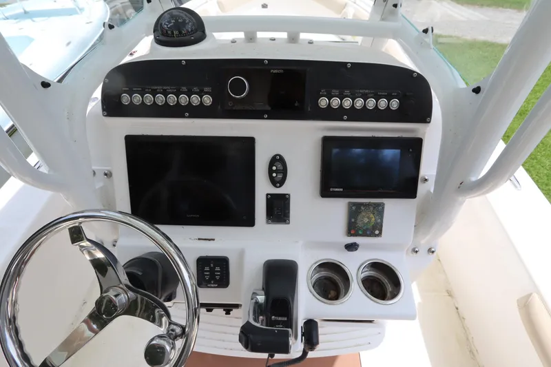 Slide: The Image of 2020 Everglades 243 Center Console boat dashboard with steering wheel and navigation controls. - 18