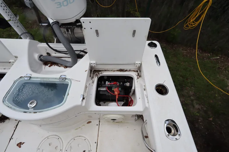 Slide: The Image of Open battery compartment on 2020 Everglades 243 Center Console boat, showing wiring and storage. - 21