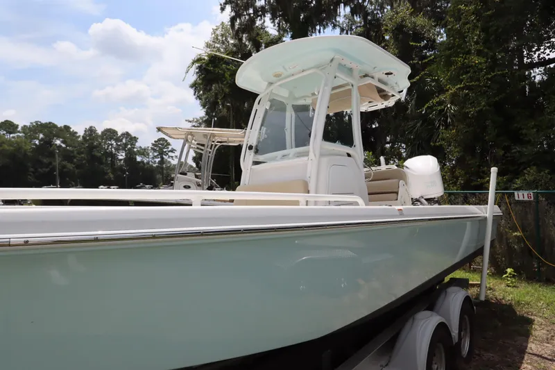 Slide: The Image of 2020 Everglades 243 Center Console boat on trailer, surrounded by trees. - 3