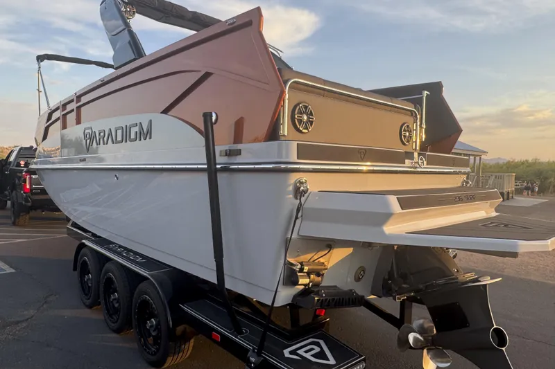 Slide: The Image of 2026 Paradigm 236 Surf boat on trailer at sunset, showcasing sleek design. - 3