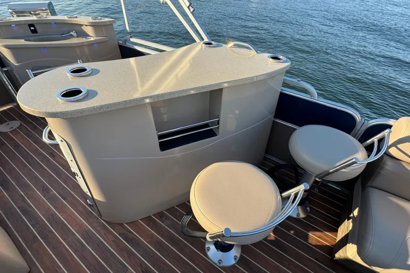Slide: The Image of Luxury bar area on 2016 Xcursion 23RFE pontoon boat with seating and cup holders. - 15