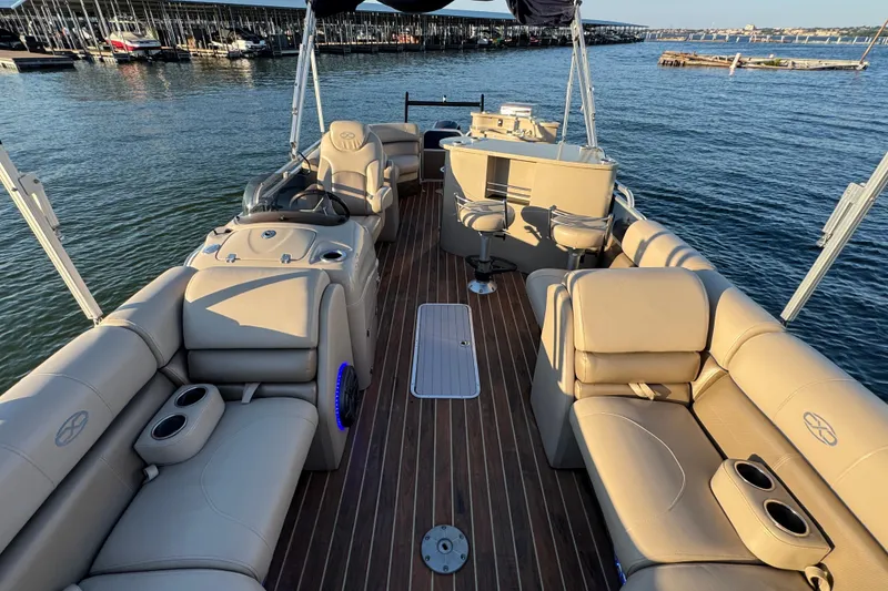 Slide: The Image of Luxurious 2016 Xcursion 23RFE pontoon boat interior with plush seating and scenic water view. - 23