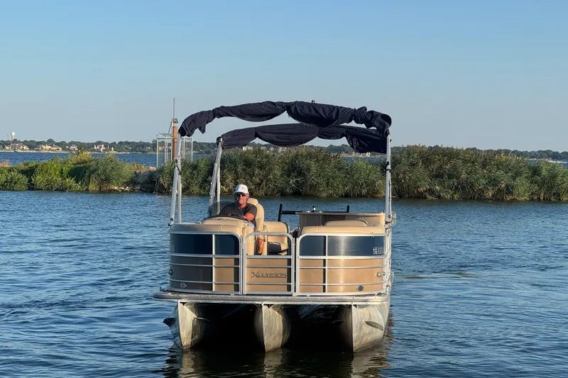 Slide: The Image of 2016 Xcursion 23RFE pontoon boat on a serene lake with lush greenery. - 3