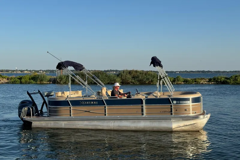 Slide: The Image of 2016 Xcursion 23RFE pontoon boat on a calm lake with clear blue skies. - 5