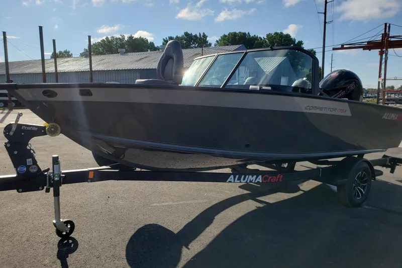 Slide: The Image of 2026 Alumacraft Competitor 175X Sport boat on trailer, parked outdoors. - 1